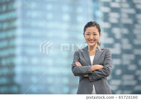 Confident businesswoman standing infront of skyscrapers Confident businesswoman standing infront of skyscrapers 65728160