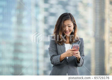 Successful businesswoman using smartphone outdoors Successful businesswoman using smartphone outdoors 65728176