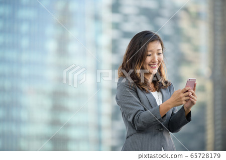 Successful businesswoman using smartphone outdoors Successful businesswoman using smartphone outdoors 65728179