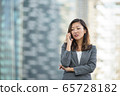 Businesswoman worried look while on voice call, using smartphone, outdoors 65728182