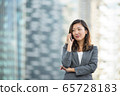 Businesswoman worried look while on voice call, using smartphone, outdoors 65728183