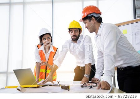 Three architects in the office and discussing Three architects in the office and discussing 65728219