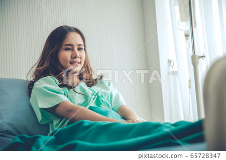 Woman patient in green shirt lying on hospital 65728347