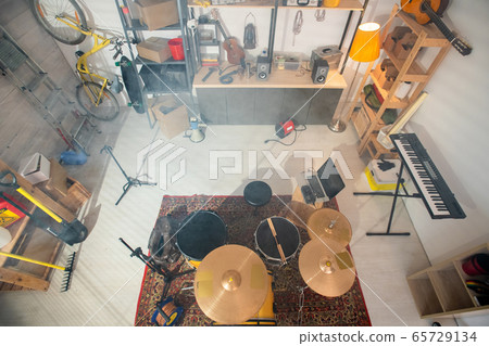 Drumset on the carpet, pianoboard, guitar and other stuff in garage Drumset on the carpet, pianoboard, guitar and other stuff in garage 65729134