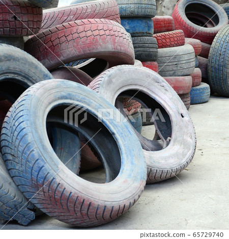 A picture of many old used tires left on a waste A picture of many old used tires left on a waste 65729740