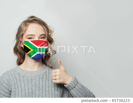 Happy woman in face mask holding thumb up Happy woman in face mask holding thumb up 65730223