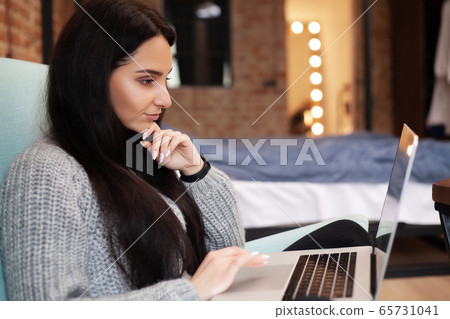 Woman works at home on a laptop during a worldwide virus epidemic 65731041