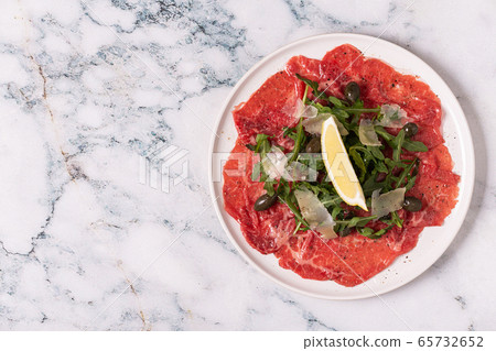 Marbled beef carpaccio with arugula, capers, lemon 65732652