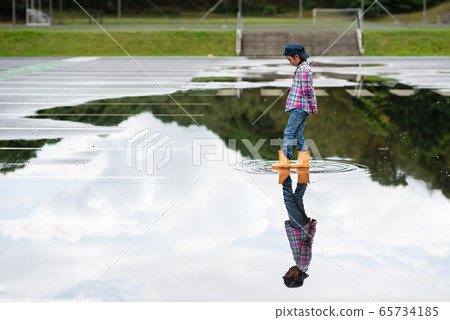 Child playing in a puddle 65734185