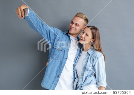 Young couple together free style isolated on grey Young couple together free style isolated on grey 65735804