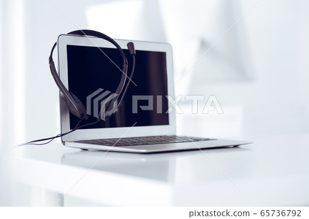 Call center and communication support, customer service help desk. VOIP headset on laptop computer Call center and communication support, customer service help desk. VOIP headset on laptop computer 65736792