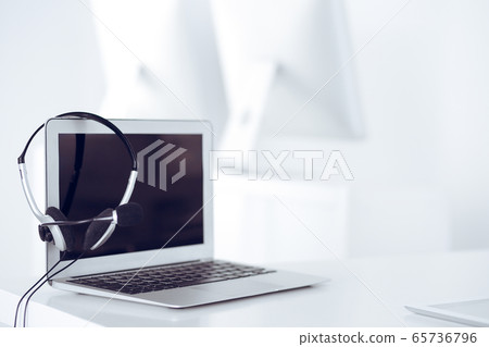 Call center and communication support, customer service help desk. VOIP headset on laptop computer Call center and communication support, customer service help desk. VOIP headset on laptop computer 65736796