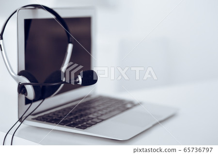 Call center and communication support, customer service help desk. VOIP headset on laptop computer Call center and communication support, customer service help desk. VOIP headset on laptop computer 65736797