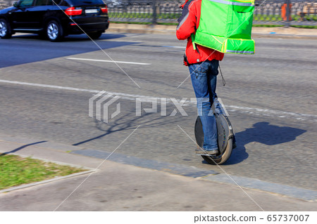 A courier with an isotherm green backpack behind. 65737007