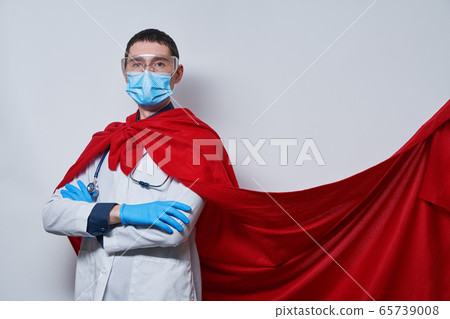 Doctor wearing surgical face mask in superhero cape. 65739008