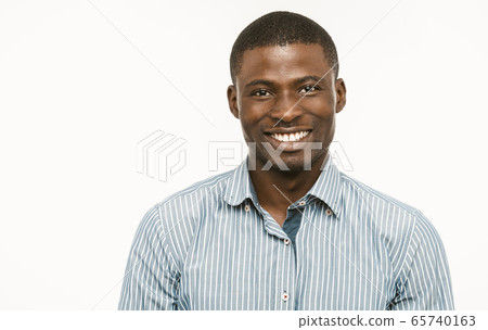 Toothy smiling african american man businessman on white background. Cheerful positive african entrepreneur with copy space at left side. Healthy teeth concept. Dental care concept. Toned image Toothy smiling african american man businessman on white background. Cheerful positive african entrepreneur with copy space at left side. Healthy teeth concept. Dental care concept. Toned image 65740163