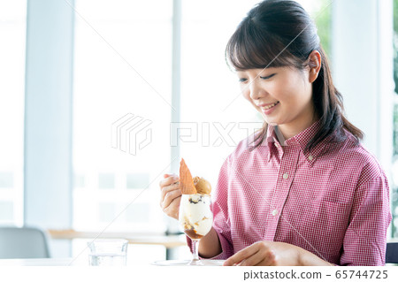 Young woman cafe eating parfait 65744725