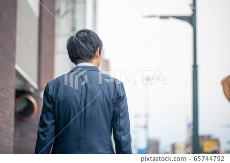 Back view of middle-aged Asian businessmen walking in the business district 65744792