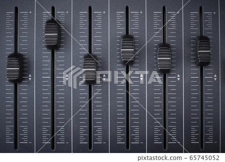Audio mixer with foreground faders ready for recording and equalizing in an audio production 65745052