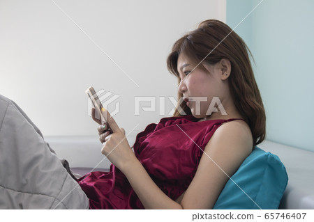 Portrait of beautiful asian woman on bed while use Portrait of beautiful asian woman on bed while use 65746407