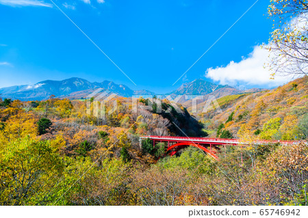 Hokuto City, Yamanashi Prefecture Higashizawa Bridge and Yatsugatake that are colored in autumn colors 65746942