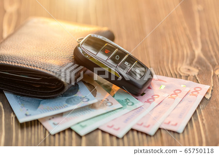 New car keys with Chinese banknote on wooden New car keys with Chinese banknote on wooden 65750118