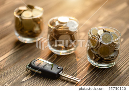 New car keys pile of coin on wooden table. Car New car keys pile of coin on wooden table. Car 65750120