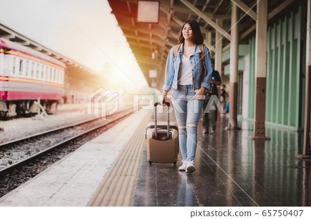 tourist woman with luggage at the train station tourist woman with luggage at the train station 65750407