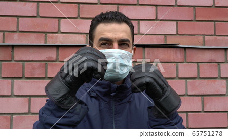 Masked man wearing boxing gloves, getting crazy, trying to protect himself from invisible threat Masked man wearing boxing gloves, getting crazy, trying to protect himself from invisible threat 65751278
