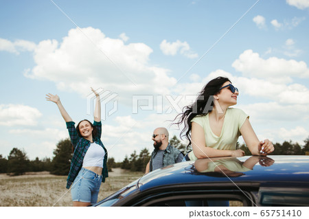 Three friends enjoying vacation travel by car 65751410
