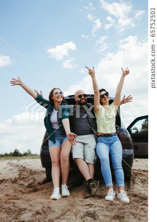 Friends traveling by car enjoy vacation together Friends traveling by car enjoy vacation together 65752501