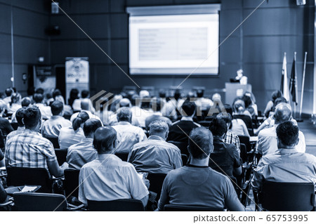 Woman giving presentation in lecture hall at university. 65753995