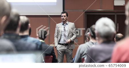 Business speaker giving a talk at business conference meeting event. Business speaker giving a talk at business conference meeting event. 65754009