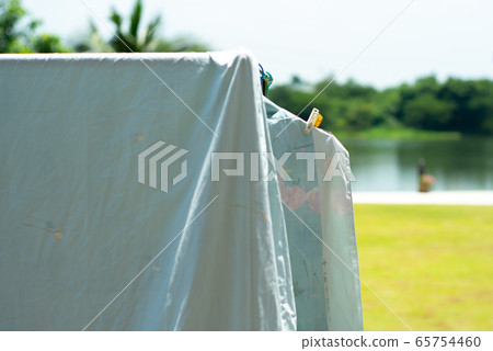 Closeup many pieces of rags hanging with clothespin for drying by the sunlight with blurred landscape background 65754460
