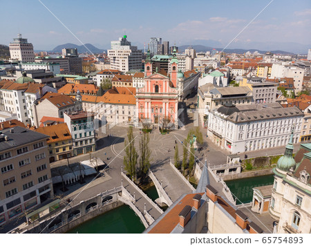 Aerial drone view of Preseren Squere and Triple Bridge over Ljubljanica river,Tromostovje, Ljubljana, Slovenia. Empty streets during corona virus pandemic social distancing measures Aerial drone view of Preseren Squere and Triple Bridge over Ljubljanica river,Tromostovje, Ljubljana, Slovenia. Empty streets during corona virus pandemic social distancing measures 65754893