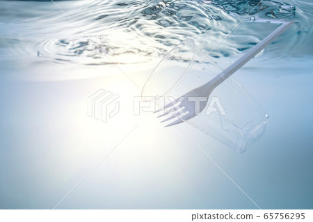 The global environmental problem, environmental pollution, waste in the seas and rivers. Plastic cup and fork, under water. 65756295