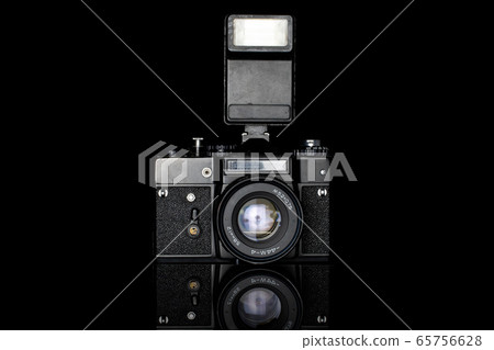 Vintage antique camera isolated on black glass Vintage antique camera isolated on black glass 65756628