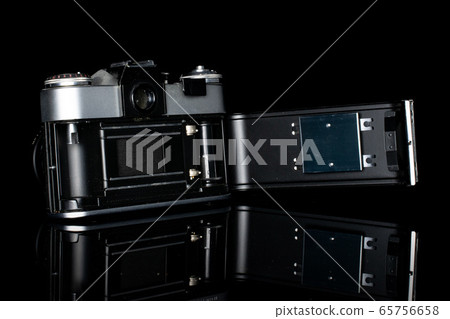 Vintage antique camera isolated on black glass Vintage antique camera isolated on black glass 65756658