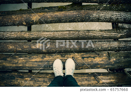 Old wooden log bridge over the river 65757668