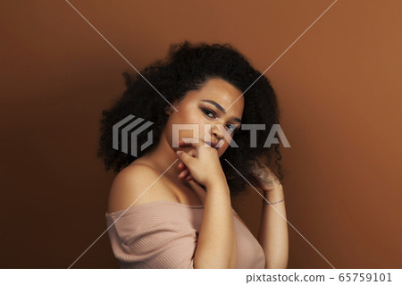 pretty young african american woman with curly hair posing cheerful gesturing on brown background, lifestyle people concept pretty young african american woman with curly hair posing cheerful gesturing on brown background, lifestyle people concept 65759101