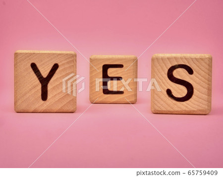 Wooden cubes with the word YES. Three wooden 65759409