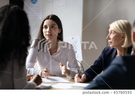 Confident young businesswoman speaking at corporate meeting in office 65760593