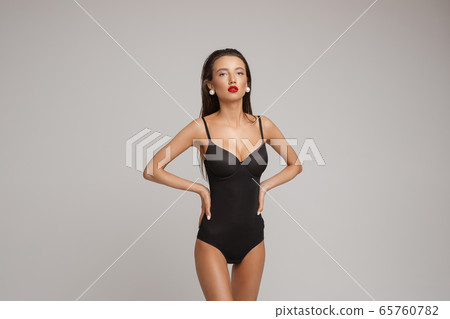 Cheerful woman in swimsuit shows different poses Cheerful woman in swimsuit shows different poses 65760782