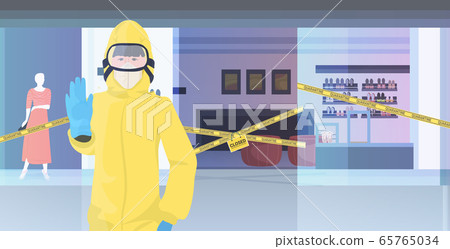 woman in hazmat suit showing stop gesture shopping mall with yellow tape coronavirus pandemic quarantine 65765034
