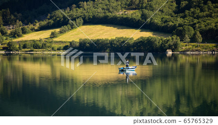 Woman fishing on a boat. 65765329