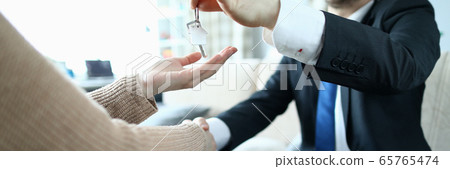 Male businessman hand passes the key to a woman from new housing 65765474