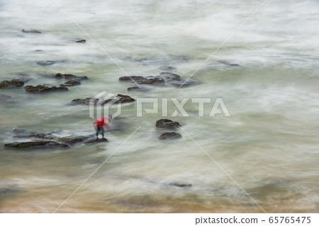 Long exposure photograph of a shellfisherman working on the rocks at Seixo beach, Torres Vedras Long exposure photograph of a shellfisherman working on the rocks at Seixo beach, Torres Vedras 65765475