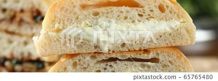 Tasty sandwich with melted cheese on a wooden board closeup background. Tasty sandwich with melted cheese on a wooden board closeup background. 65765480