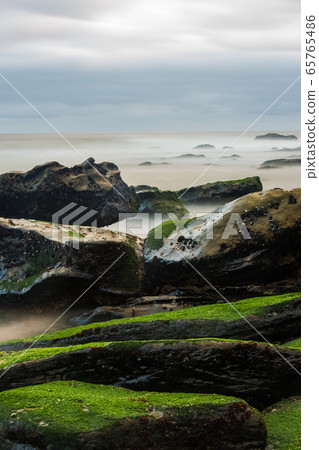 Long exposure photography of sea waves and mist on the rocks of the shore of Porto Novo 65765486