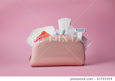 feminine pads, tampon and razor in the cosmetic bag 65765934